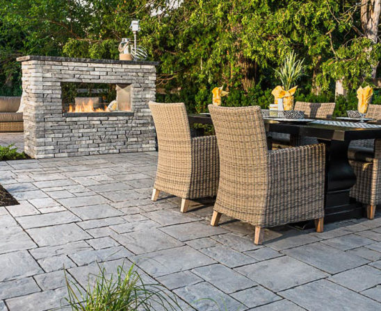 unilock thornbury pavers in almond grove with stone outdoor fireplace