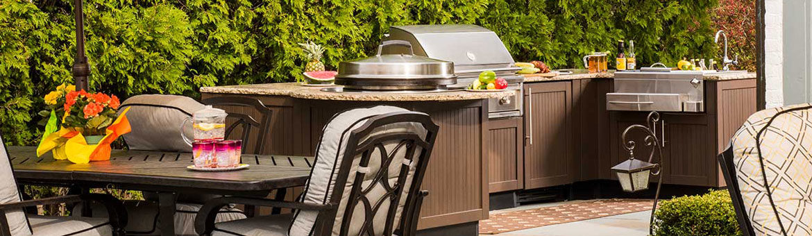 brown jordan outdoor kitchen with built in grill and outdoor bar on thermalled bluestone flagstone patio with cast aluminum outdoor dining furniture and yellow patio umbrella