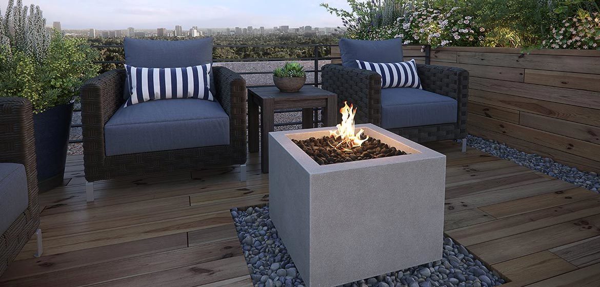 eldorado outdoor bloc fire bowl single on wooden deck with mexican beach pebbles and wicker outdoor furniture