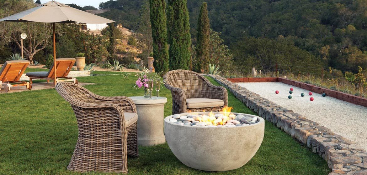 eldorado outdoor infinite fire bowl near bocce court with wicker seating in beautiful mountain setting