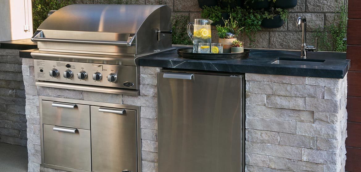 eldorado outdoor kitchen with silver stackstone veneer and black granite countertop and built in grill