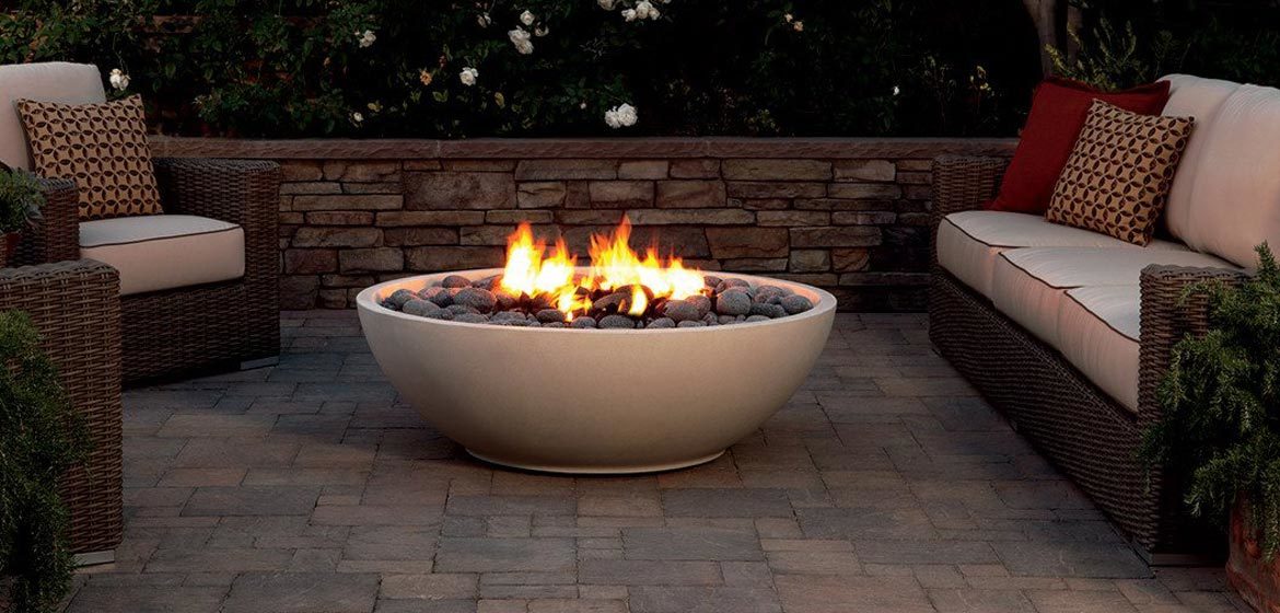 eldorado outdoor mezzaluna fire bowl on concrete paver patio with wicker furniture