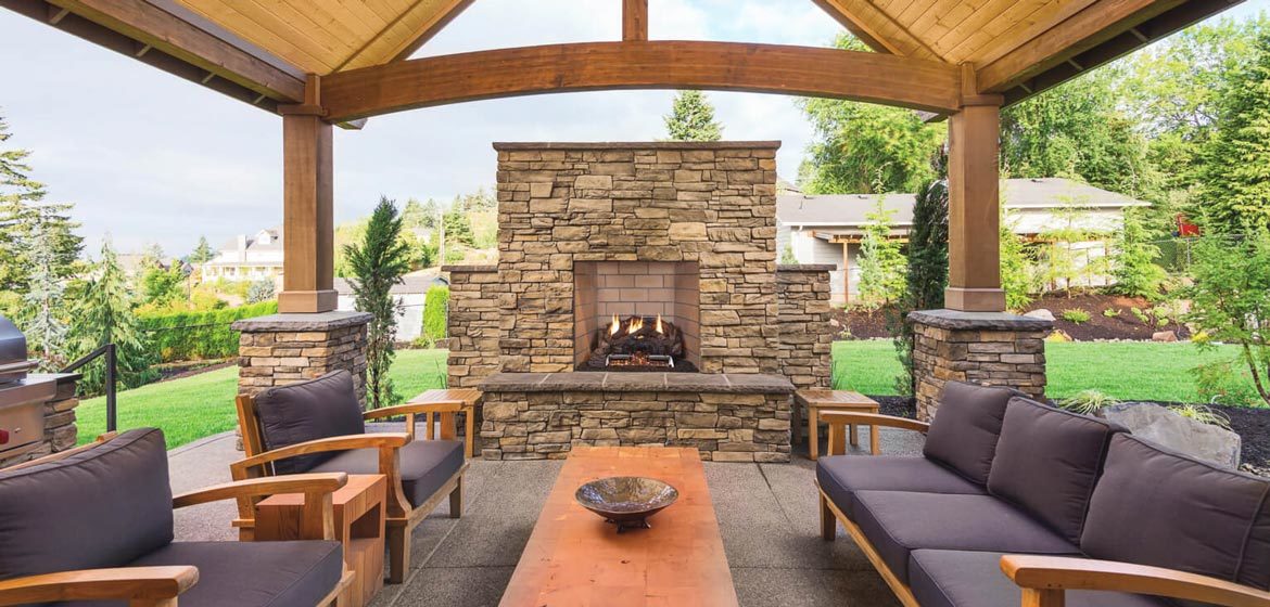 isokern standard outdoor fireplace under beautiful wooden pavilion with teak sofas and long rectangular teak coffee table