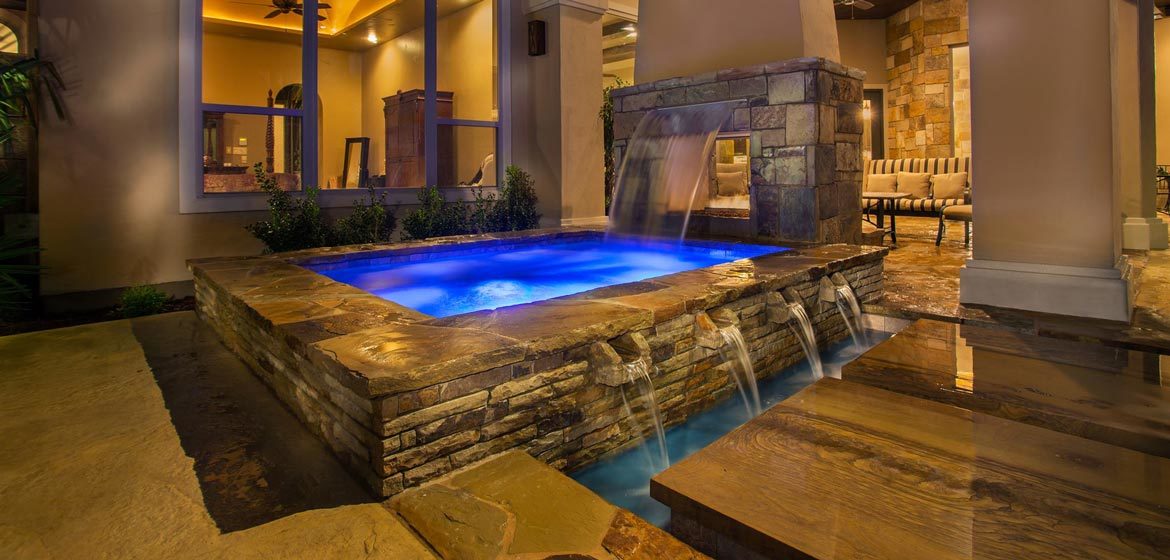 isokern see through outdoor fireplace interior view with adjacent waterfalls and polished brentwood countertop stone