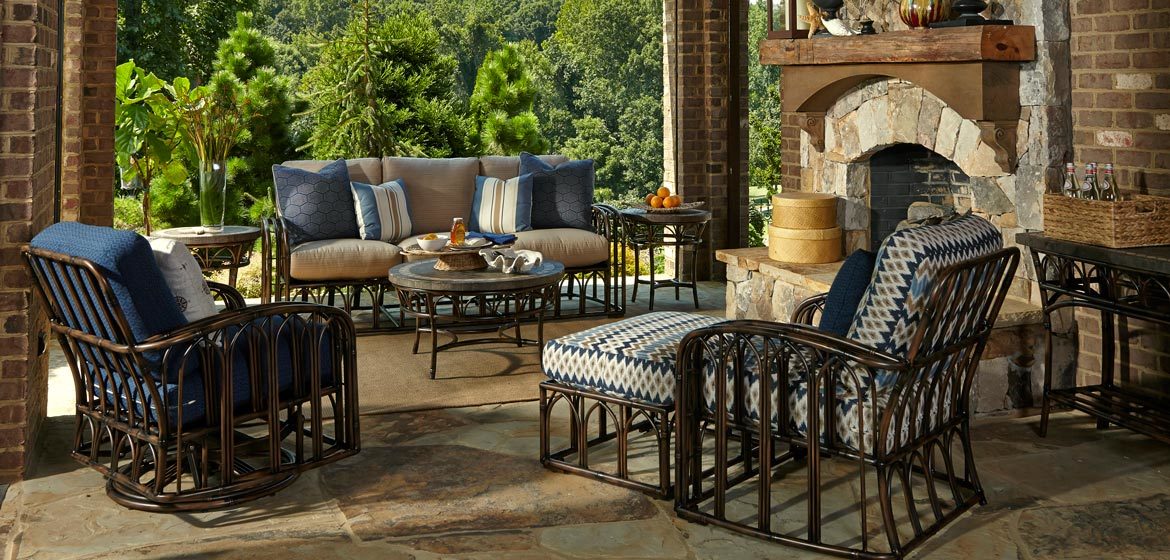 Klaussner Outdoor Capella rattan cushion seating on irregular flagstone patio with beautiful stone fireplace