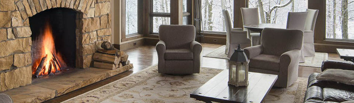 superior clay rumford fireplace with natural stone facade and stone hearth in beautiful sunroom in the woods with snow falling