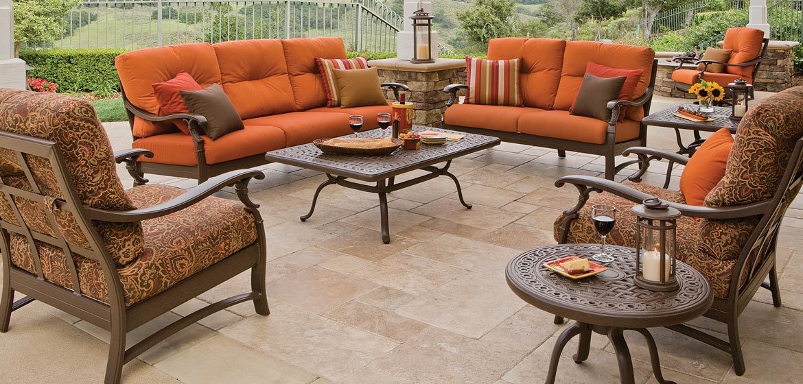 Tropitone's Ravello outdoor sofa, lounge chairs and coffee table on a travertine patio under a pergola