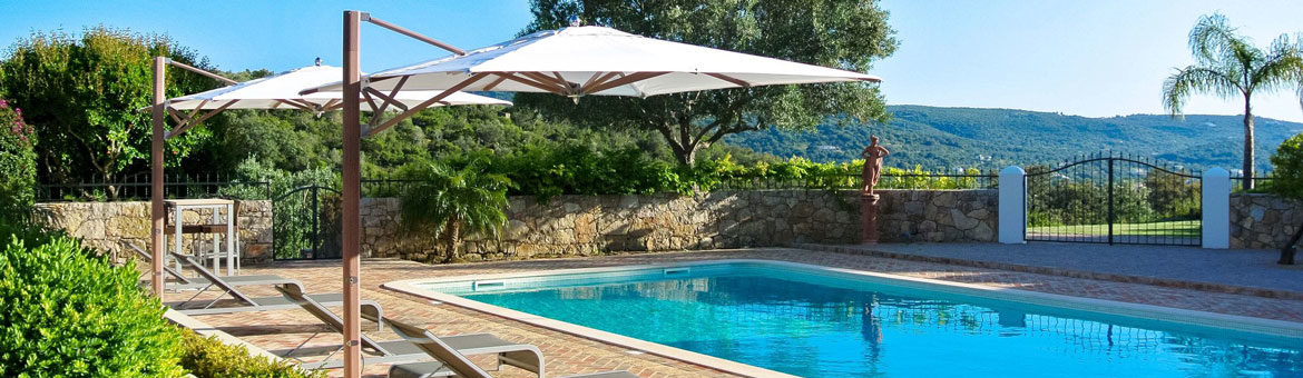 tuuci single cantilever umbrella on brick pool deck with sling chaise loung chairs