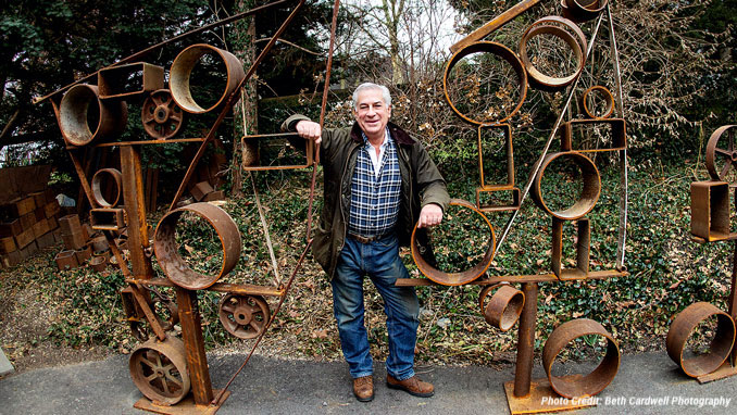 David Rosenfeld posing with a metal sculpture.