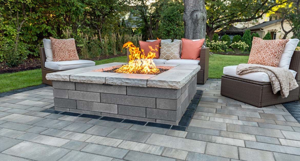 unilock artline pavers surround this lino fire pit with contemporary wicker furniture